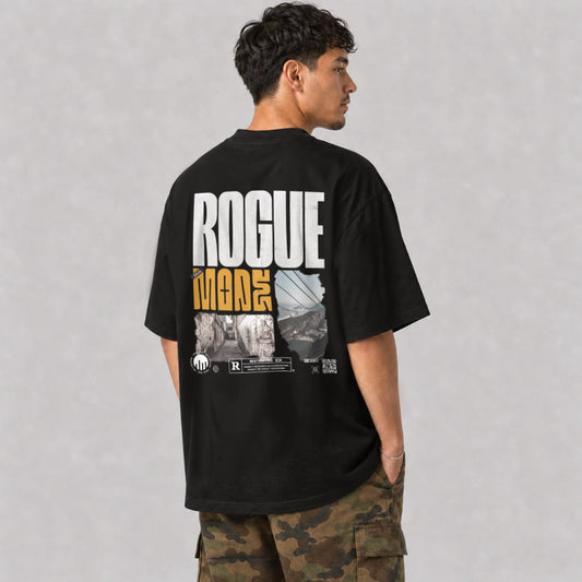 Ein schwarzes Oversized T-Shirt der Marke FORCE ZERO im Rogue Mode Raw Design am Model in der Produkt-Rückansicht mit dem großen weißen Schriftzug „ROGUE“, dem darunterstehenden gelben Wort „MODE“ sowie zwei Foto-Prints einer Gasse und einer Seilbahn inklusive eines „RESTRICTED“ Parental-Advisory-Style-Logos am unteren Rand.