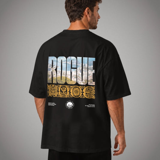 Ein schwarzes Oversized T-Shirt der Marke FORCE ZERO im Rogue Mode Rio X Design am Model in der Produkt-Rückansicht mit einem großen Print, bei dem das Wort „ROGUE“ mit einer Luftaufnahme von Rio de Janeiro gefüllt ist, darunter das goldene barocke Wort „MODE“ steht und drei weiße Branding-Logos am unteren Rand platziert sind.
