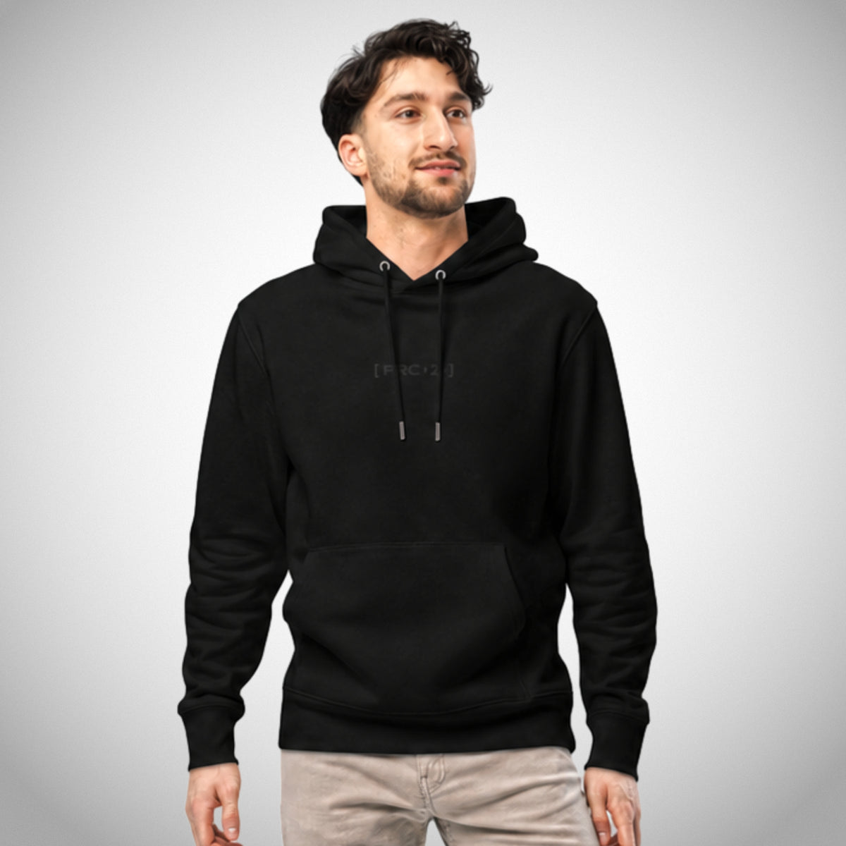 Ein schwarzer Regular Fit Hoodie der Marke FORCE ZERO im Black Stealth Design zeigt als Ganzkörper-Modellbild die Vorderansicht an einem männlichen Model mit beiger Hose, wobei mittig auf der Brust das dezent schwarz gestickte Brustemblem „[FRC-Z]“ platziert ist.