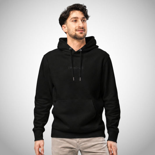 Ein schwarzer Regular Fit Hoodie der Marke FORCE ZERO im Black Stealth Design zeigt als Ganzkörper-Modellbild die Vorderansicht an einem männlichen Model mit beiger Hose, wobei mittig auf der Brust das dezent schwarz gestickte Brustemblem „[FRC-Z]“ platziert ist.