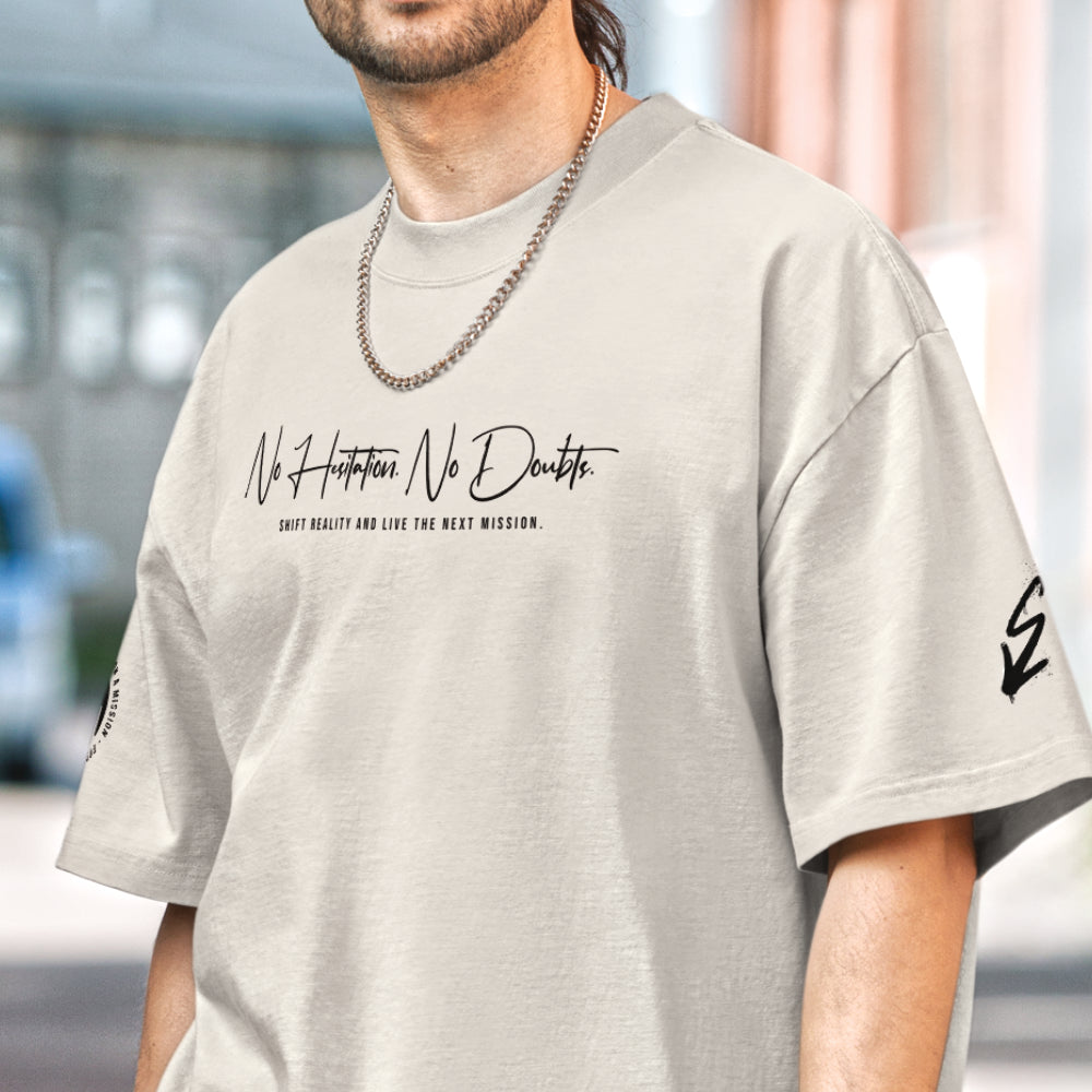 Sandfarbenes Oversized T-Shirt im Signature Fit der Marke FORCE ZERO aus der NHND Design-Schiene am Model in der Vorderansicht mit dem schwarzen Schriftzug „No Hesitation. No Doubts. SHIFT REALITY AND LIVE THE NEXT MISSION.“ auf der Brust sowie Grafikprints auf den Ärmeln.
