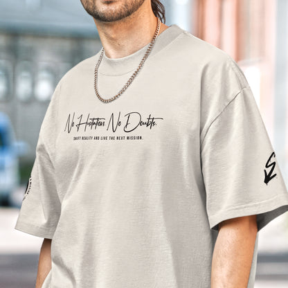 Sandfarbenes Oversized T-Shirt im Signature Fit der Marke FORCE ZERO aus der NHND Design-Schiene am Model in der Vorderansicht mit dem schwarzen Schriftzug „No Hesitation. No Doubts. SHIFT REALITY AND LIVE THE NEXT MISSION.“ auf der Brust sowie Grafikprints auf den Ärmeln.