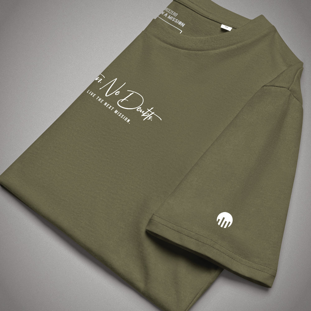 Nahaufnahme eines gefalteten olivgrünen T-Shirts im Core Fit der Marke FORCE ZERO mit Fokus auf das runde weiße Logo auf dem Ärmel, den weißen „No Doubts.“ Schriftzug auf der Brust und dem sichtbaren Nackenprint FORCEZERO ON A MISSION im Kragen.