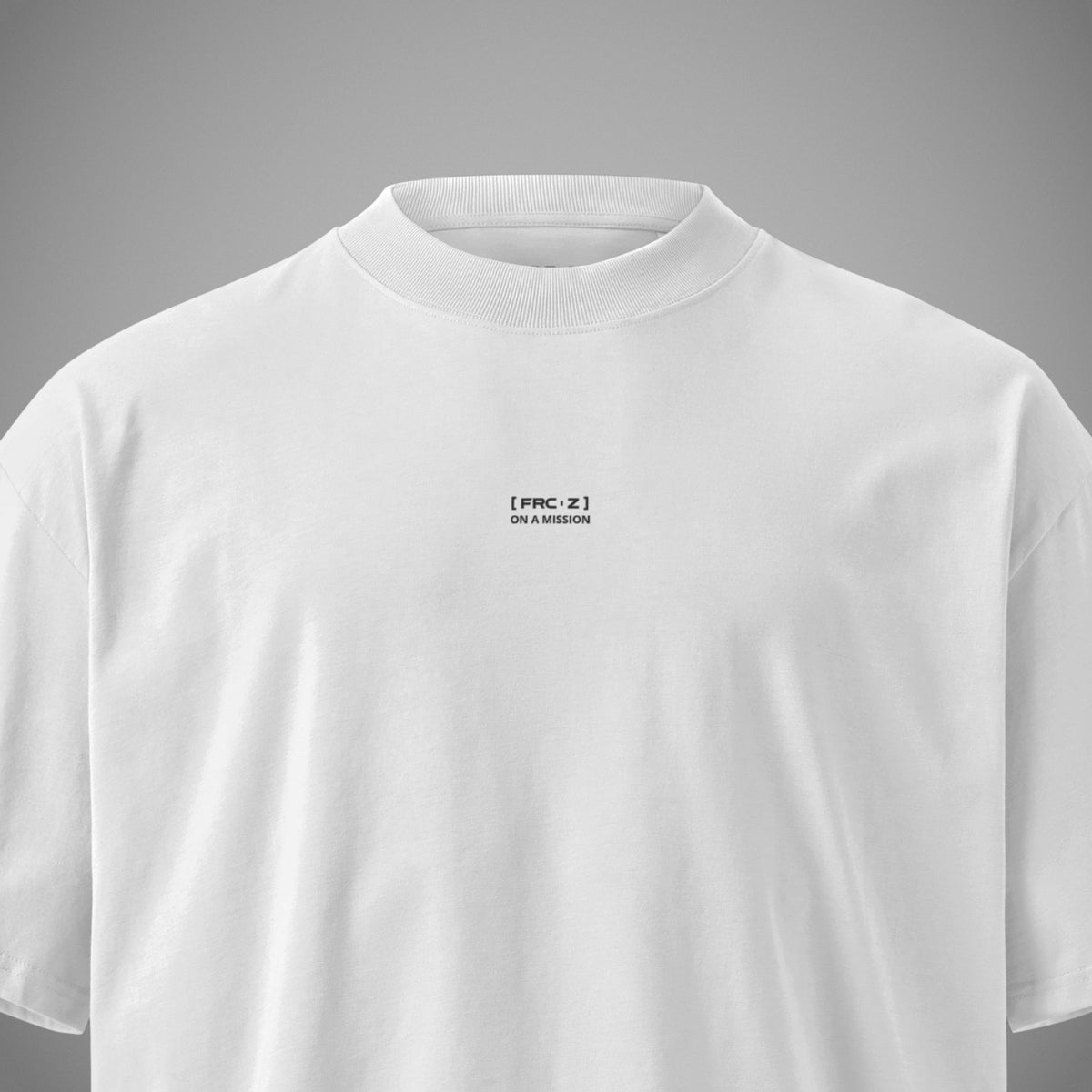 Detailansicht des kleinen schwarzen Print-Logos mit dem Slogan ON A MISSION auf der Brust eines weißen Oversized T-Shirts der Marke FORCE ZERO aus der RAW GRIT COLLECTION.