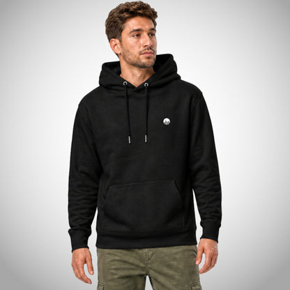 Ein schwarzer Core Fit Hoodie der Marke FORCE ZERO im Raw Rio Design zeigt als Ganzkörper-Modellbild die Vorderansicht an einem männlichen Model mit olivgrüner Cargo-Hose, wobei auf der linken Brust das runde weiße Logo-Emblem kontrastierend abgebildet ist.