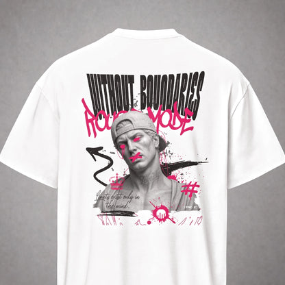 Ein weißes Oversized T-Shirt der Marke FORCE ZERO im Rogue Mode Renegade Design in der Produkt-Rückansicht (Mockup) in der Totalen mit dem großen schwarzen Grafikprint „WITHOUT BOUNDARIES“ und dem pinken Graffiti-Schriftzug „Rogue Mode“ über dem Schwarz-Weiß-Porträt eines Mannes mit pinken Akzenten sowie der geschwungenen Textzeile „Limits exist only in the mind.“.